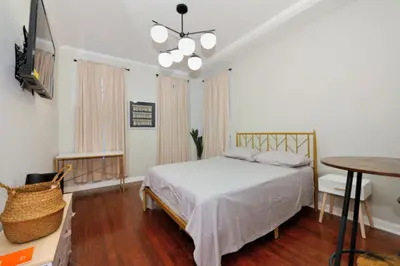 a bedroom with a bed and a table and a television at Cozy Studio Near Central Park in New York