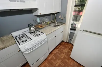 a kitchen with a white stove and a white refrigerator at Cozy Studio Near Central Park in New York