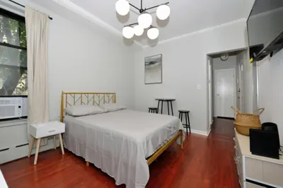 a bedroom with a bed and a table and chairs at Cozy Studio Near Central Park in New York