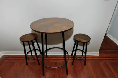 a table and two stools sitting next to a wall at Cozy Studio Near Central Park in New York