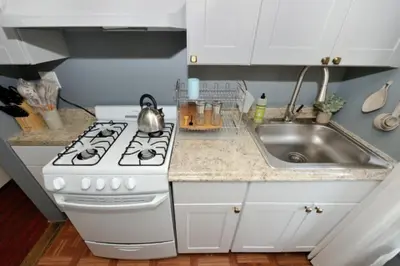 a kitchen with a white stove and a sink at Cozy Studio Near Central Park in New York