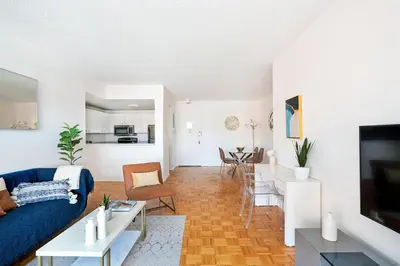 a living room with a blue couch and a table at Sunny 3 BR 1 Bath Apartment in NYC in New York