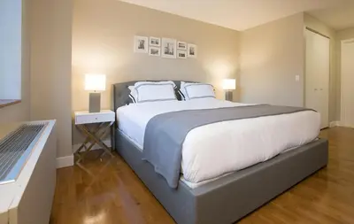 a bedroom with a large bed with white sheets and pillows at Fully Furnished 2BR 2Bath Unit in NYC in New York