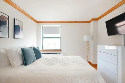 a white bedroom with a bed and a television at Contemporary 2 Bed 2 Bath Apt Bright and Sunny in New York