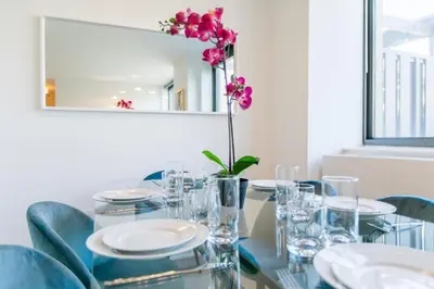 a dining room table with a vase with a flower on it at Bright 2 Bedrooms 2 Bathrooms Unit in New York