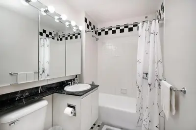 a black and white bathroom with a sink and a shower at Stunning Apartment for 4 2 Bedrooms 2 Bath in New York