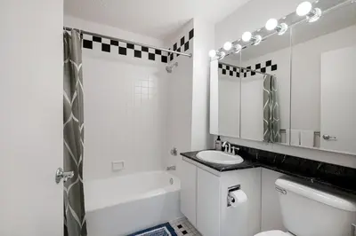 a white bathroom with a toilet and a shower at Stunning Apartment for 4 2 Bedrooms 2 Bath in New York