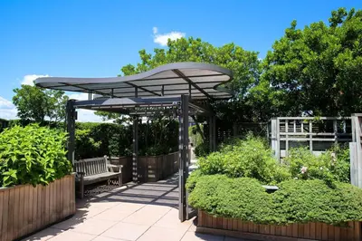 a bench under an umbrella in a garden at Luxury 2 Bed 2 Bath Unit in Prime Location of NYC in New York
