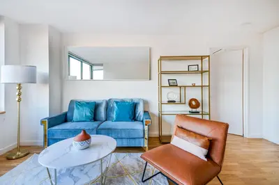 a living room with a blue couch and a table at Luxury 2 Bed 2 Bath Unit in Prime Location of NYC in New York