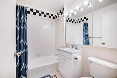 a white bathroom with a toilet and a sink at Luxury 2 Bed 2 Bath Unit in Prime Location of NYC in New York