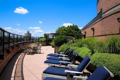 a row of blue lounge chairs on a patio at Luxury 2 Bed 2 Bath Unit in Prime Location of NYC in New York