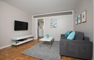 a living room with a couch and a television at 2 Bed Apt Ideally located in UES of Manhattan in New York