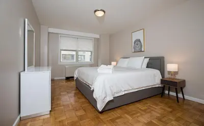 a bedroom with a large bed with white sheets and white pillows at 2 Bed Apt Ideally located in UES of Manhattan in New York