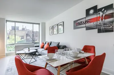 a living room with red chairs and a couch at Beautiful 1 Bed Fully Furnished Apartment in New York