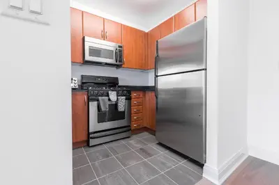 a kitchen with a stainless steel refrigerator and a microwave at Beautiful 1 Bed Fully Furnished Apartment in New York