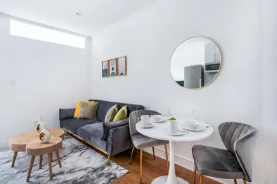 a living room with a couch and a table and a mirror at 1 BR Gem in Prime Location of NYC in New York