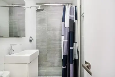 a bathroom with a shower curtain and a sink at 1 BR Gem in Prime Location of NYC in New York