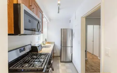 a kitchen with a stove and a refrigerator at Lovely Studio New York Apartment in New York