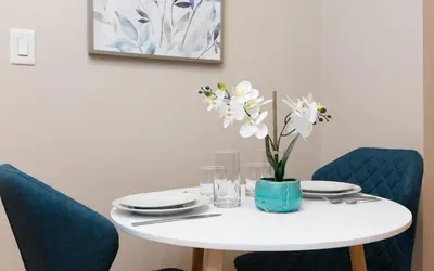 a white table with a vase of white flowers on it at Lovely Studio New York Apartment in New York