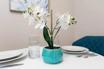 a blue vase with white flowers on a table at Lovely Studio New York Apartment in New York