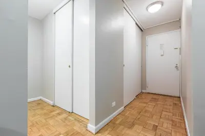 a hallway with white walls and a wooden floor at Lovely Studio New York Apartment in New York