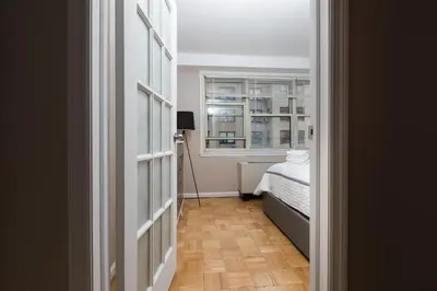 a hallway with a bed and a window at Lovely Studio New York Apartment in New York