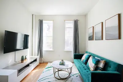 a living room with a green couch and a tv at Contemporary 1 Bedroom Apartment in NYC in New York