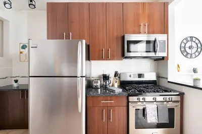 a kitchen with a stainless steel refrigerator and a microwave at Contemporary 1 Bedroom Apartment in NYC in New York