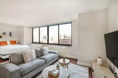 a living room with a couch and a bed at Gorgeous Studio Apartment in New York