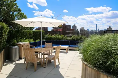a table and chairs with an umbrella on a patio at Gorgeous Studio Apartment in New York
