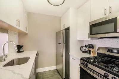 a kitchen with a stainless steel refrigerator and a sink at Gorgeous Studio Apartment in New York