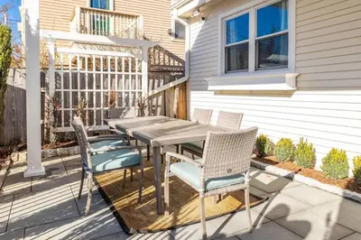 a patio with a table and chairs in front of a house at Cottage At Yale in New Haven