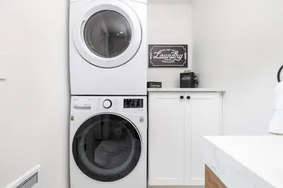 a washer and dryer in a white kitchen at Cottage At Yale in New Haven