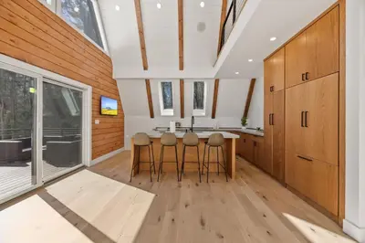 a kitchen with wooden cabinets and a kitchen island with stools at The Windham A in Windham