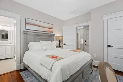 a white bedroom with a large bed and a chair at Red Cross Haven in New Haven