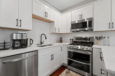 a white kitchen with a stove and a microwave at Red Cross Haven in New Haven