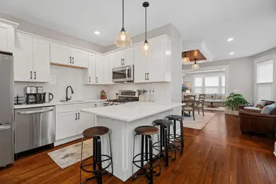 a kitchen with white cabinets and bar stools at Red Cross Haven in New Haven