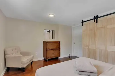 a bedroom with a bed and a chair and a dresser at Charming Family Saratoga Home Walk to Track & Downtown in Saratoga Springs