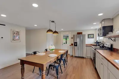 a kitchen with a wooden table and chairs in a kitchen at Charming Family Saratoga Home Walk to Track & Downtown in Saratoga Springs