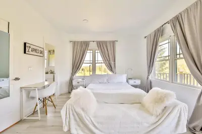 a white bedroom with a bed and a desk at Trailside Escape 2BR Views Fireplace & Balcony in Hunter