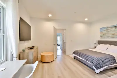 a white bedroom with a bed and a television at Trailside Escape 2BR Views Fireplace & Balcony in Hunter