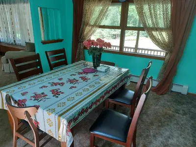 a dining room table with a vase of flowers on it at Spacious House with a Pool in Glen Spey