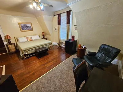 a living room with a bed and a chair at Inn at Lake Joseph in Forestburgh