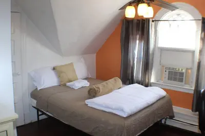 a small bed in a room with a window at Whitney Wonder 2nd and 3rd floor in Hartford