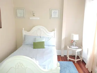 a white bed with a green pillow on it at Whitney Wonder 2nd and 3rd floor in Hartford