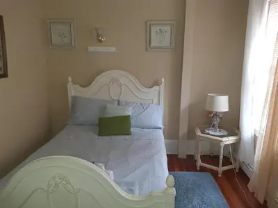 a bedroom with a white bed with a green pillow at Whitney Wonder 2nd and 3rd floor in Hartford