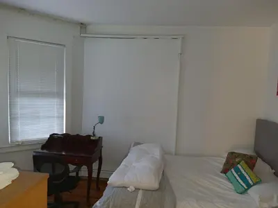 a bedroom with a bed and a desk and a window at Whitney Wonder 2nd and 3rd floor in Hartford