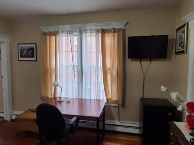 a living room with a table and a television at Whitney Wonder 2nd and 3rd floor in Hartford
