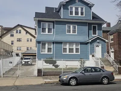 a blue house with a car parked in front of it at Judees' Comfort 3 in Newark