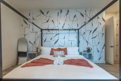 a bedroom with a large bed with two white shoes on it at Bright & Bold+NYC View, Sleep 13, Park 2 cars FREE in East Orange